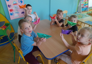Dzieci pokazują zrobione przez siebie łódki.