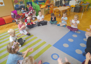 Dzieci klaszczą w rytm muzyki.
