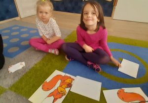 Dziewczynki prezentują swoją pracę - wiewiórka z puzzli.