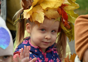 Dziewczynka z wiankiem z liści na głowie.