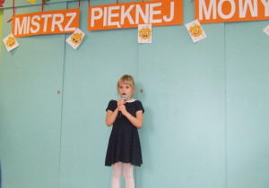 Dziewczynka prezentuje wierszyk.