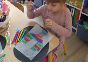 Dzieci kopiują litery na kalce.