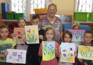Dzieci wspólnie z artystką prezentują gotowe prace.
