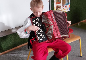 Chłopiec gra na akordeonie.