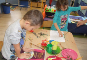 Dzieci tworzą obraz z pomocą sznurka.