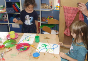 Dzieci malują sznurkiem.