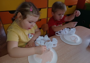 Dzieci przyklejają łańcuchy do papierowego talerza