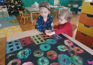 Dzieci kolorują domy na plakacie