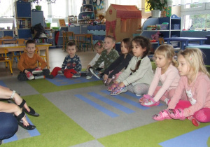 Dzieci naśladują ruchy nauczycieli z wykorzystaniem butów.