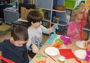 Dzieci przyklejają paski bibuły.