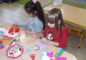 Dzieci przyklejają koła origami i bibułę.