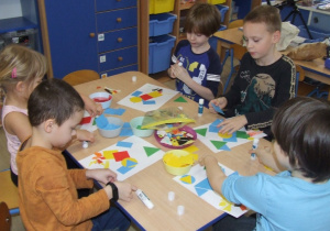 Dzieci tworzą rakietę z figur geometrycznych.