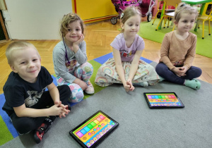 Dzieci grają na dzwonkach w aplikacji na tabletach.