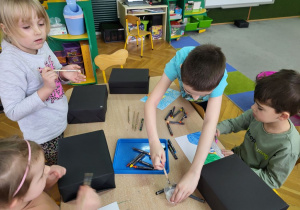 Dzieci wykonują model telewizora z pudełka i papieru.