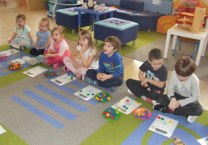 Dzieci wykonują ćwiczenia buzi i języka podczas gry w bingo.