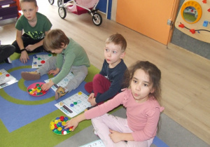 Dzieci wydmuchują powietrze podczas gry w bingo.