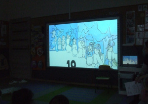 Dzieci oglądają bajkę "Dziesięć bałwanków" na tablicy multimedialnej
