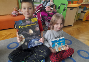 Dzieci pokazują książki.