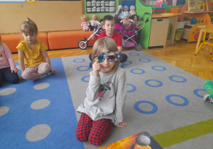 Dziewczynka przymierza okulary 3D.