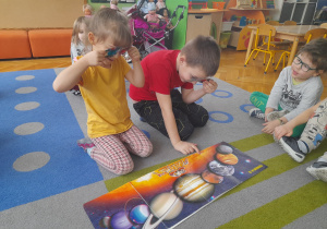 Dzieci oglądają planety przez okulary 3D.