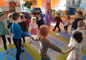 Dzieci tańczą po kole.