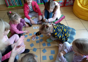 Dzieci grają w memory obrazkowe.