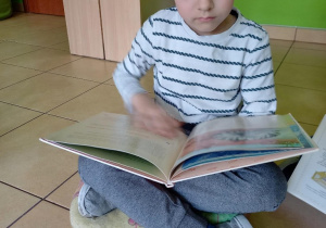 Dziecko ogląda książki.