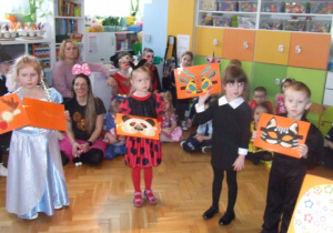 Dzieci prezentują maski karnawałowe.