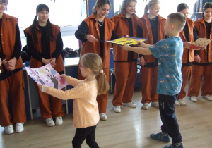 Dzieci wręczają podziękowania tancerzom.