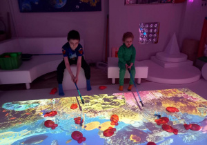 Dzieci łowią ryby na podłodze interaktywnej.