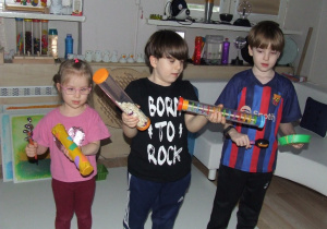 Dzieci grają na wykonanych przez siebie instrumentach.
