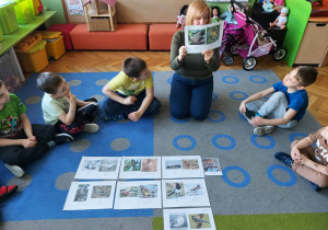 Dzieci oglądaja ilustracje z ptakami.