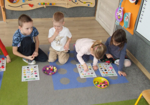 Dzieci układają żetony na wylosowanych obrazkach.