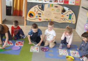 Dzieci układają żetony na wylosowanych obrazkach.