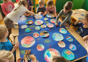 Dzieci wykonują zespołową pracę plastyczną - Kosmos.
