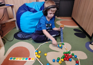 Chłopiec gra w grę kolorowa gąsienica.