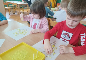 Dzieci robią stempelki za pomocą słomki
