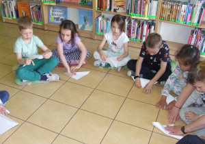 Dzieci składają papier według instrukcji - tworzą motyle.