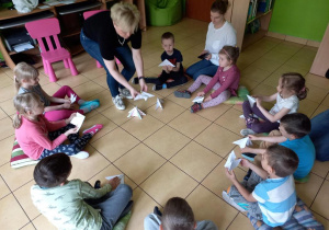 Dzieci składają motyle z papieru.