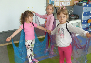 Dziewczynki przebrane za motyle rozkładają skrzydła.