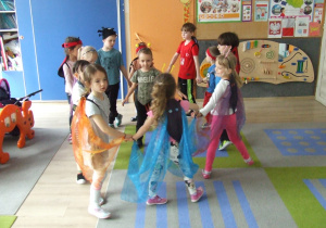 Dzieci przebrane za owady tańczą w kole.