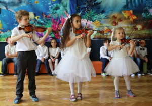 Dzieci z grupy drugiej grają na skrzypcach.
