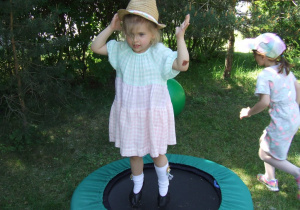 Dziewczynka skacze na trampolinie.