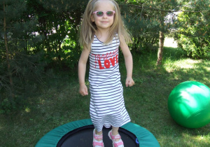 Dziewczynka skacze na trampolinie.