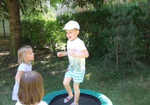 Chłopiec skacze na trampolinie.