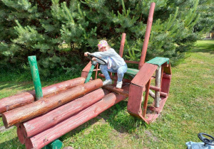 Dziecko na drewnianym traktorze.