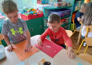 Dzieci przyklejają liście herbaty i ziół