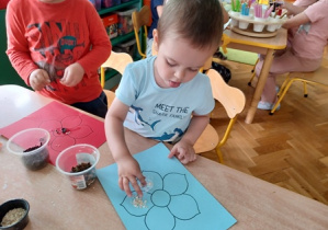 Dzieci przyklejają liście herbaty i ziół