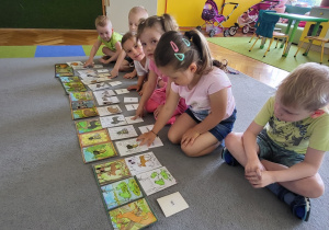 Dzieci układają loteryjkę obrazkową o zwierzętach leśnych.