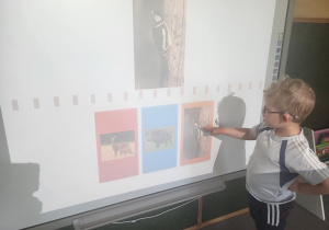 Dziecko wskazuje zwierzęta leśne na tablicy interaktywnej.
